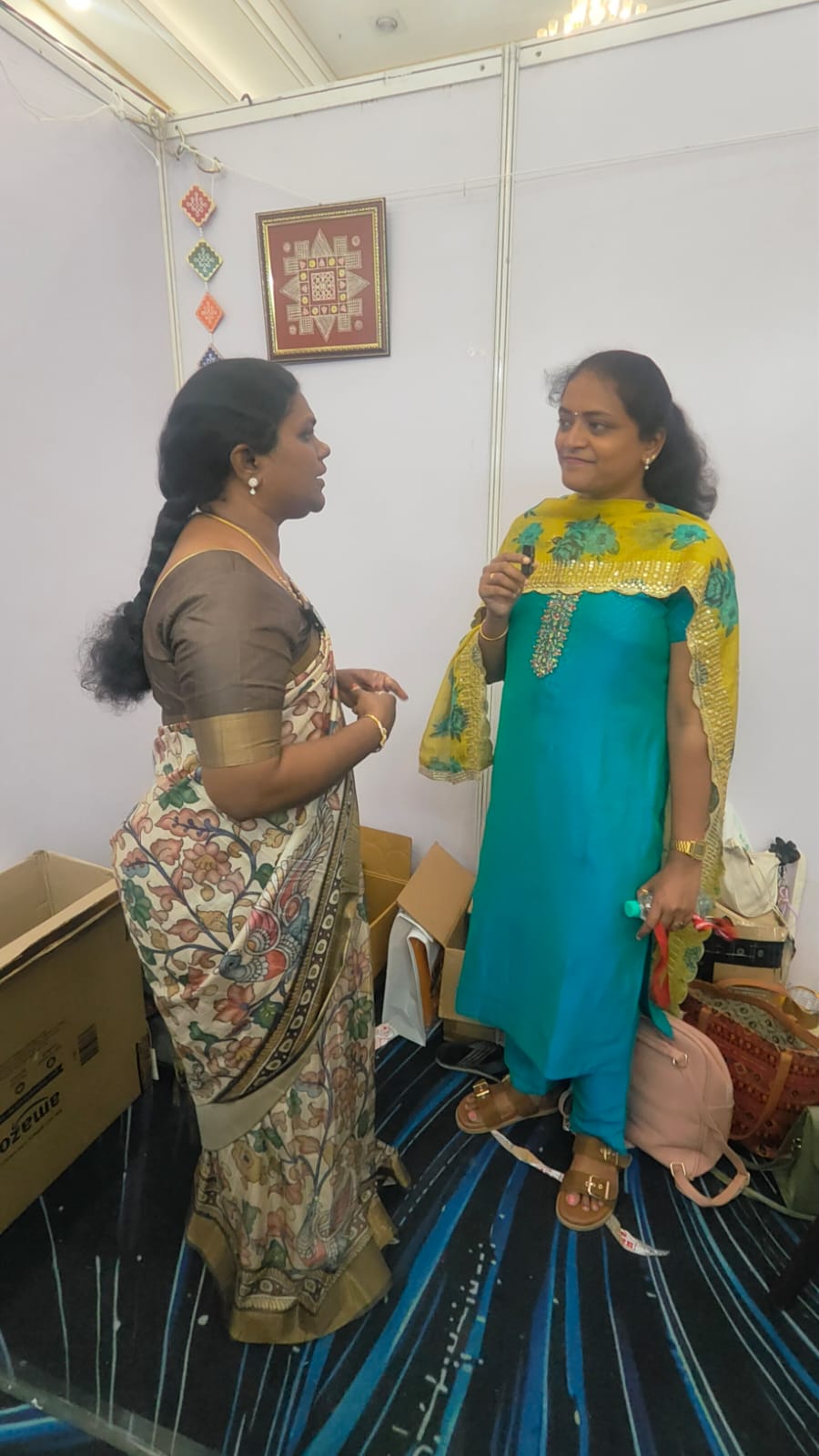 Meena Ramasamy speaking with a visitor at the stall