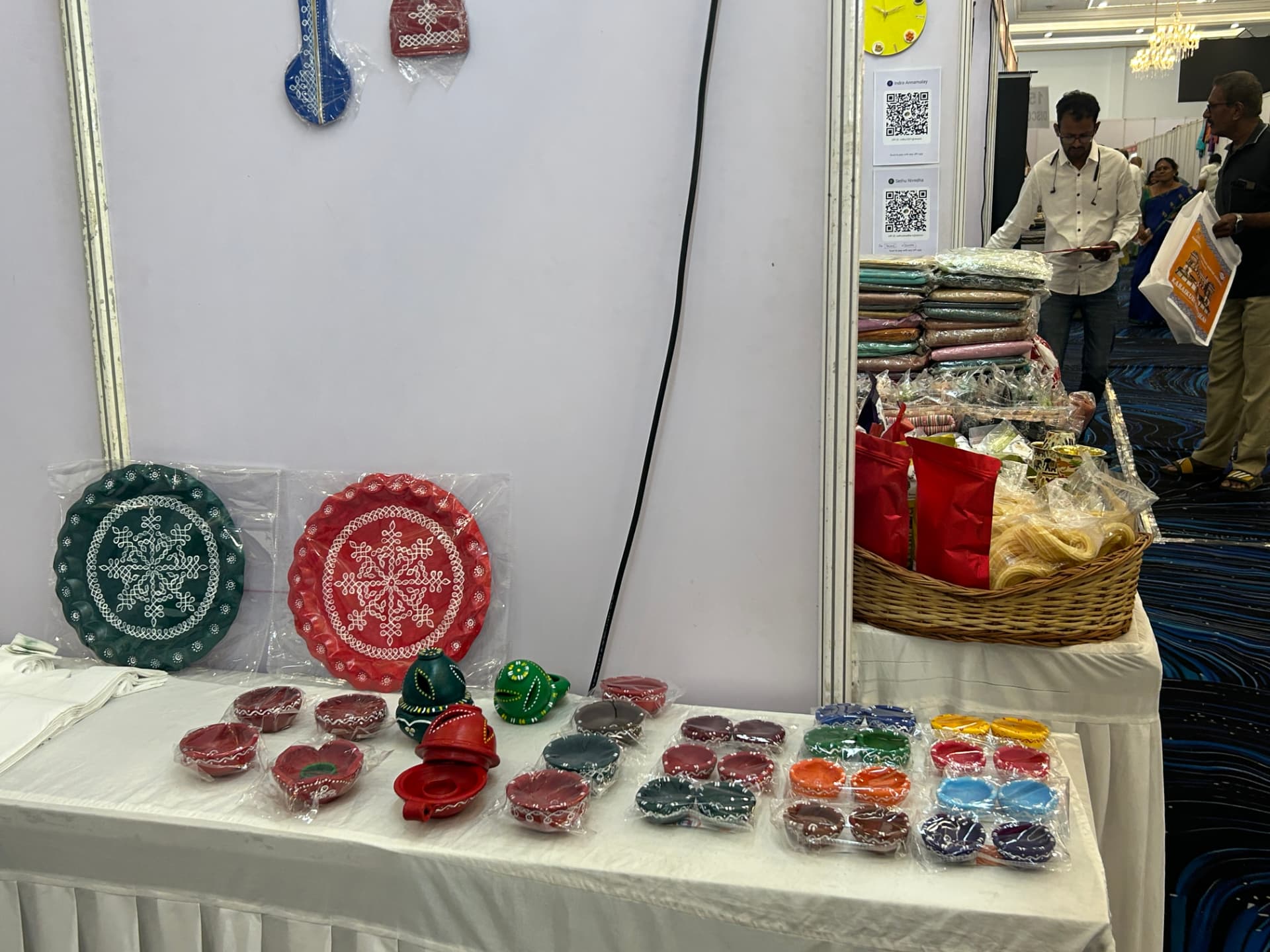 Hand-painted plates and clay diyas at the stall counter